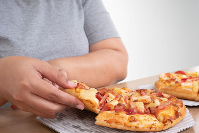 Midsection of woman holding ice cream on table