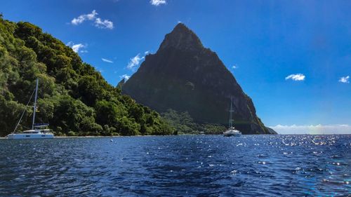 Scenic view of sea and mountains against blue sky