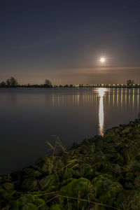 Scenic view of lake against sky at night