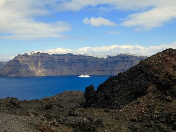 View of passenger craft in bay of water by mountains 