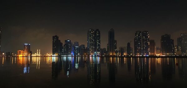 Illuminated buildings against sky at night