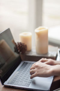 Cropped image of woman using laptop