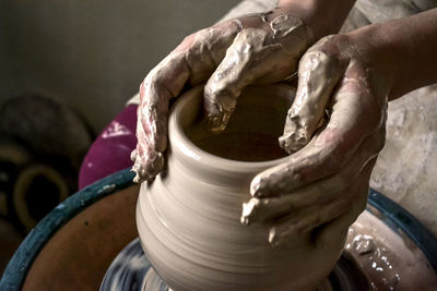 Girl sculpts in clay pot closeup. modeling clay. caucasian man making vessel daytime of white clay  