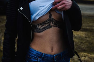 Midsection of woman showing tattoo