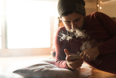 Young man using mobile phone at home