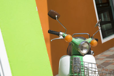 Close-up of motor scooter parked against wall