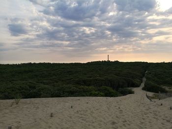 Scenic view of beach against cloudy sky