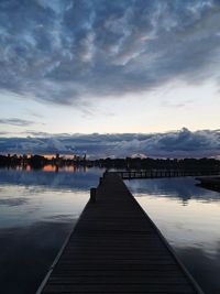 Pier over lake against sky during sunset
