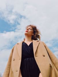 Low angle view of woman looking away against sky