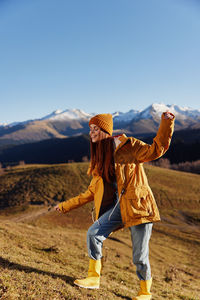 Rear view of woman standing on field