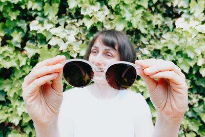 Midsection of woman holding coffee at park