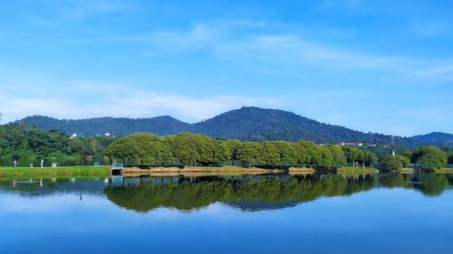 Scenic view of lake and mountains against blue sky