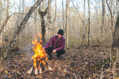 Man roasting food in campfire at forest