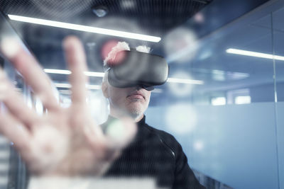 Senior man in virtual reality headset using advanced technology