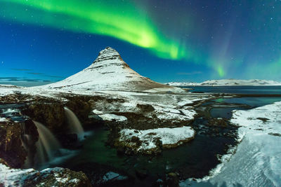 Scenic view of snowcapped mountains against sky at night