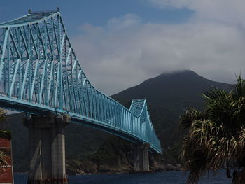 Bridge by mountains against sky