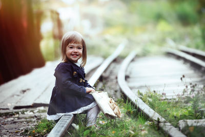 Portrait of happy girl sitting outdoors