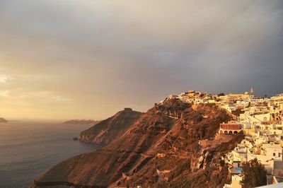 Buildings on mountain against sky at santorini during sunset