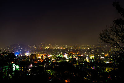 Illuminated cityscape against sky at night