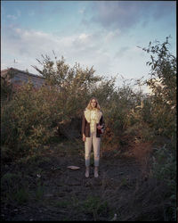 Full length of woman standing by tree against sky