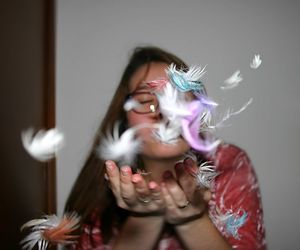 Woman blowing feathers at home