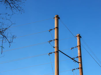 Electric pole with a linear wire against the blue sky close-up. power electric pole.
