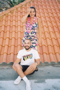 Portrait of a smiling young couple sitting outdoors