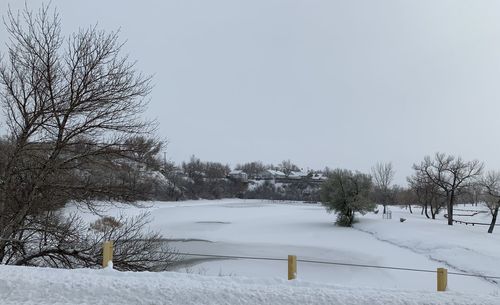 Snow covered field against clear sky