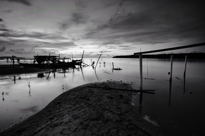 Pier on lake against sky during sunset