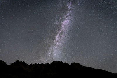 Milky way a and sky full of stars above mountain ridge silhouette , slovakia, europe