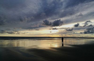 Scenic view of beach against dramatic sky