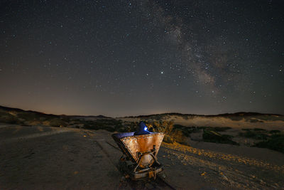 Lifeguard hut on land against star field at night