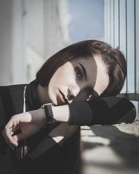 Portrait of young woman leaning on retaining wall