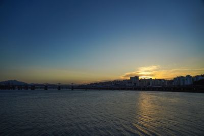 Scenic view of sea and buildings against sky during sunset