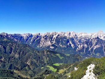 Scenic view of snowcapped mountains against clear blue sky