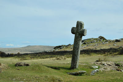 Cross on landscape against sky