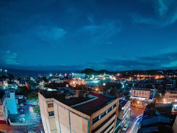 High angle view of illuminated city against sky at dusk