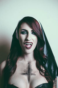 Portrait of beautiful young woman against gray background