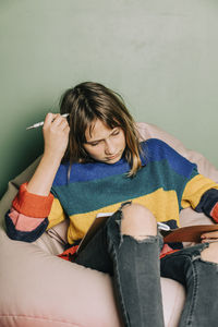 Girl with notebook and pen studying at home