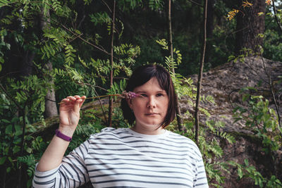 Portrait of woman holding plant