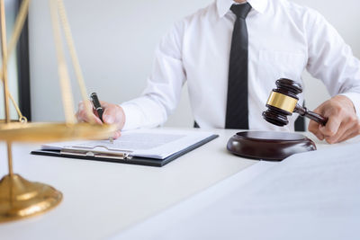 Midsection of man using laptop on table