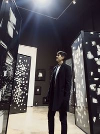 Full length of man standing in illuminated room