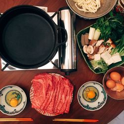 Directly above food ingredients with cooking pan and stove on table