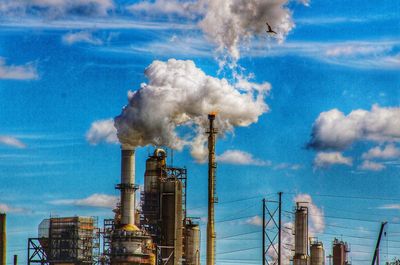 Industrial building against cloudy sky