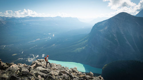 Panoramic view of man standing on rocks against mountains