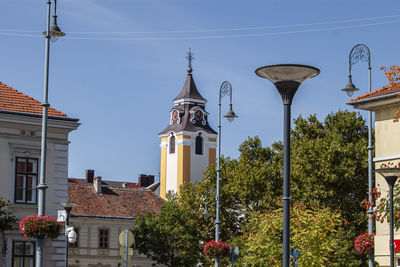 Low angle view of street light by building against sky