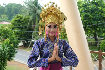 Portrait of woman in traditional clothing standing by column