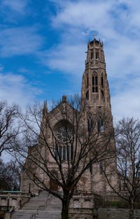 Low angle view of tree and building against sky