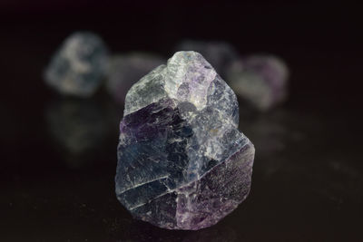 Close-up of ice crystals on rock against black background