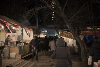 Rear view of people in city at night